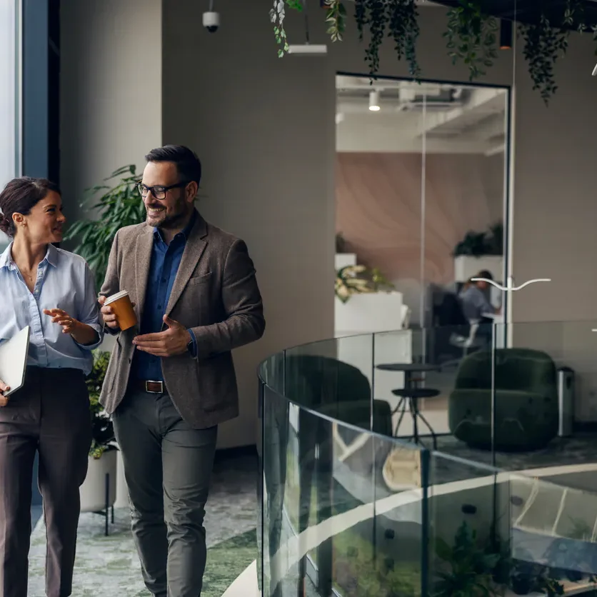 Business partners walking next to modern office windows