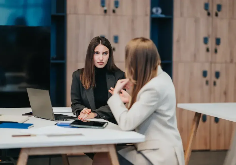 Two business partners in a direct conversation across a desk