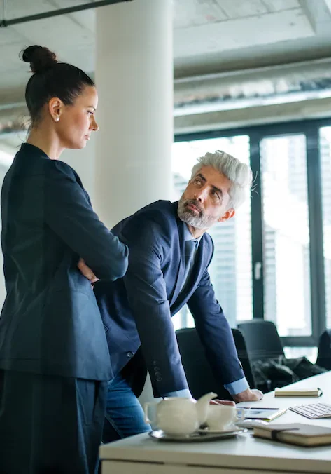 Two business partners looking at the same screen at a shared desk
